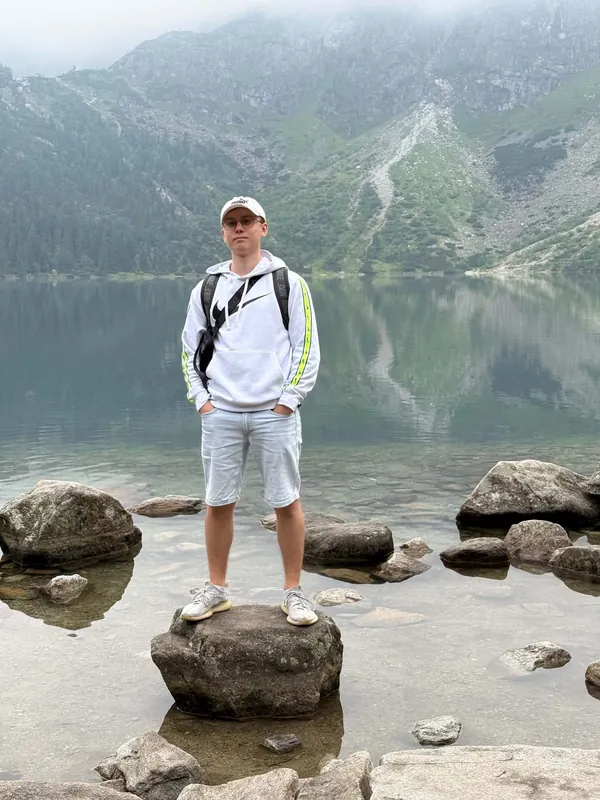 Morskie Oko lake in the Tatra Mountains, standing on a boulder at the shoreline
